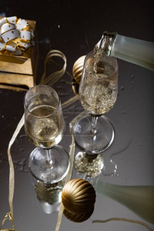 Photo for Two champagne glasses reflecting in glass New Year background - Royalty Free Image