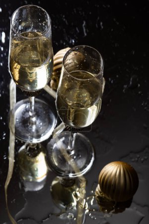 Photo for Two champagne glasses reflecting in glass New Year background - Royalty Free Image