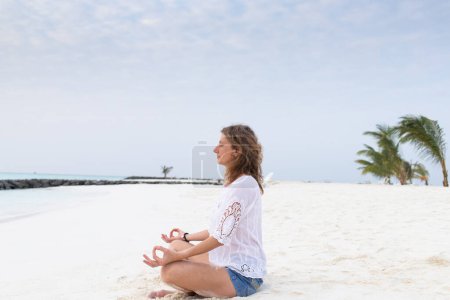 Téléchargez les photos : Femme en posture de méditation au bord de la mer - en image libre de droit