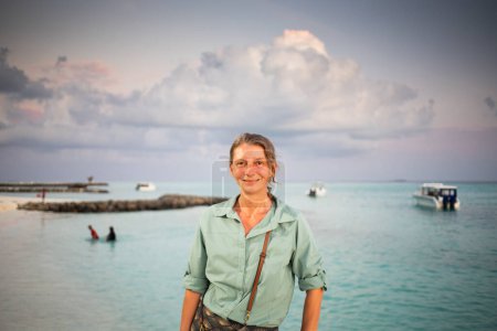 Photo for Woman looking at pink sunset over tropical sea freedom - Royalty Free Image