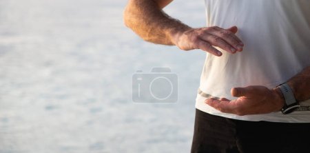 Mann praktiziert Qigong am Meer