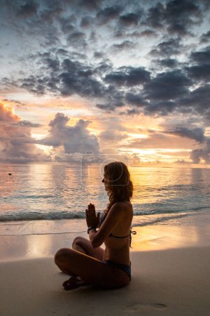 Foto de Mujer haciendo yoga en playa exótica - Imagen libre de derechos