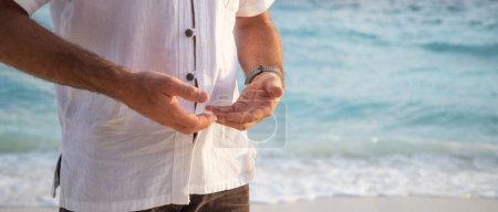 Téléchargez les photos : Homme pratiquant le qigong au bord de la mer - en image libre de droit