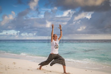 Photo for Woman doing yoga on exotic beach - Royalty Free Image
