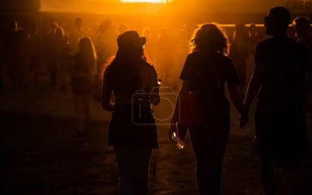 Foto de Siluetas de personas caminando en el festival de la puesta del sol - Imagen libre de derechos