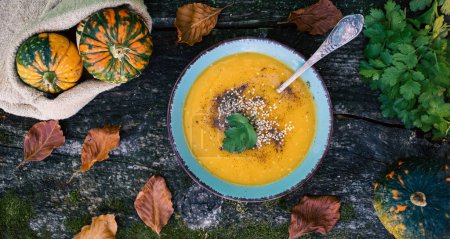 Photo for Pumpkin soup on wooden table autumn dish - Royalty Free Image