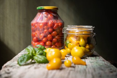 Photo for Red and yellow cherry tomatoes in a jar for winter - Royalty Free Image