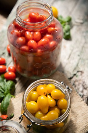 Foto de Tomates cherry rojos y amarillos en un frasco para el invierno - Imagen libre de derechos