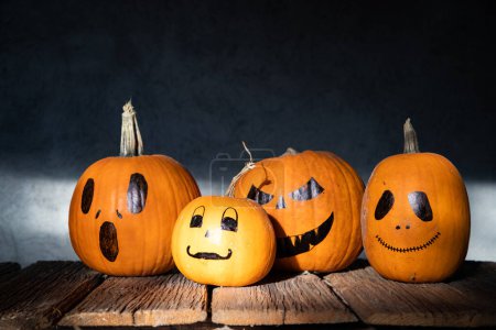 Photo for Scary funny Halloween pumpkins on wooden table - Royalty Free Image