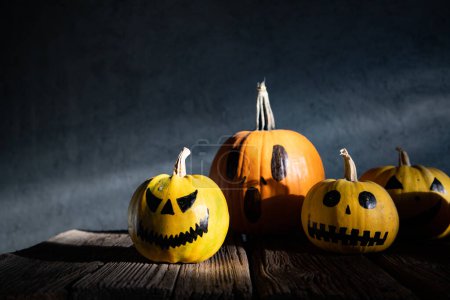 Photo for Scary funny Halloween pumpkins on wooden table - Royalty Free Image