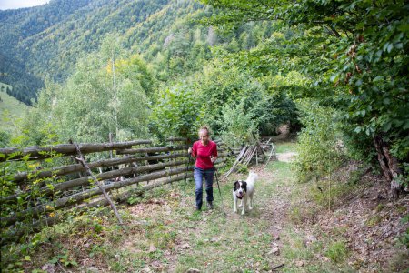 Téléchargez les photos : Femme trekking avec chien à la campagne - en image libre de droit