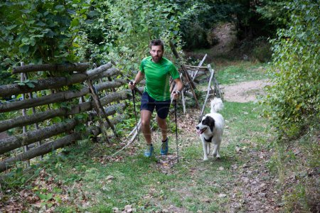 Téléchargez les photos : Homme trekking avec chien à la campagne - en image libre de droit