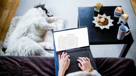Foto de Mujer en casa con perro hygge en Navidad - Imagen libre de derechos