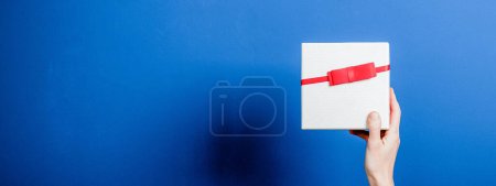 Téléchargez les photos : Vue de dessus des mains féminines tenant cadeau de Noël - en image libre de droit