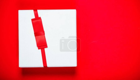 Téléchargez les photos : Vue du dessus de la boîte cadeau rwhite sur rouge et ruban - en image libre de droit