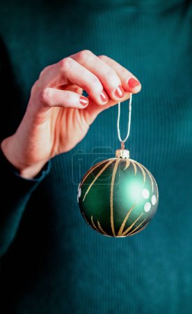 Téléchargez les photos : Femme tenant une boule de Noël verte - en image libre de droit