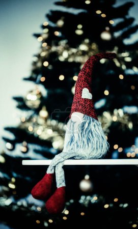 Téléchargez les photos : Gnome assis devant l'arbre de Noël - en image libre de droit