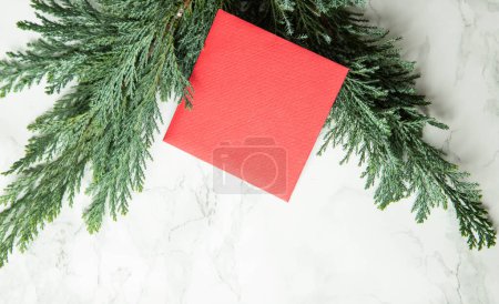 Foto de Tarjeta roja de Navidad en ramas de abeto verde - Imagen libre de derechos