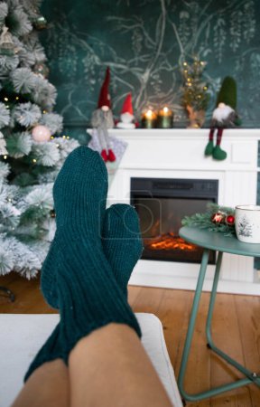 Photo for Woman in wool socks warming in front of firepalce - Royalty Free Image