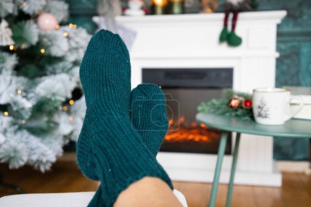 Photo for Woman in wool socks warming in front of firepalce - Royalty Free Image
