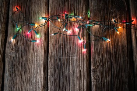 Photo for Red Christmas lights on wooden table - Royalty Free Image