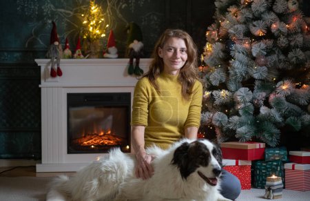 Téléchargez les photos : Heureux chien blanc devant l'arbre de Noël - en image libre de droit