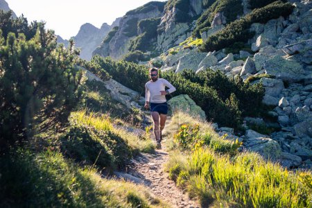 Foto de Corredor de senderos corriendo en el paisaje de montaña al atardecer estilo de vida activo - Imagen libre de derechos