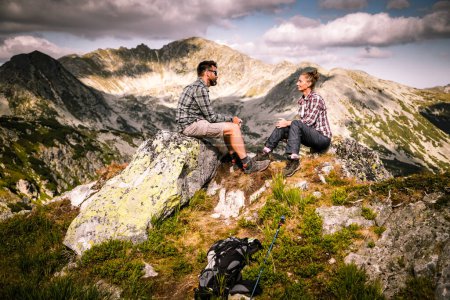 Photo for Couple sitting on mountain top in amazing summer landscape - Royalty Free Image