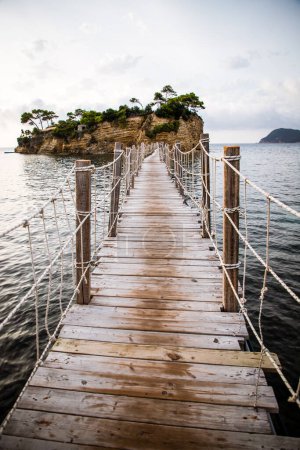 Téléchargez les photos : Passerelle en bois menant à la petite île d'Agios Sostis sur Zakynthos, Grèce, par une journée ensoleillée d'été - en image libre de droit