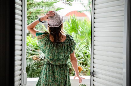 Téléchargez les photos : Femme bénéficiant d'une végétation luxuriante en face de la chambre d'hôtel - en image libre de droit
