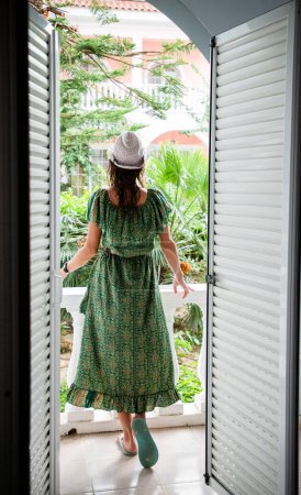 Téléchargez les photos : Femme bénéficiant d'une végétation luxuriante en face de la chambre d'hôtel - en image libre de droit