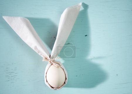 Photo for Egg wrapped in easter bunny shaped napkin - Royalty Free Image