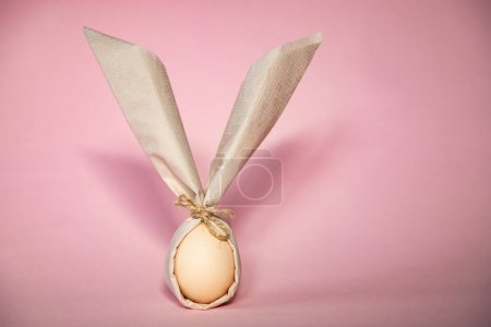Téléchargez les photos : Oeuf enveloppé dans une serviette en forme de lapin de Pâques - en image libre de droit