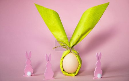 Téléchargez les photos : Oeuf enveloppé dans une serviette en forme de lapin de Pâques - en image libre de droit