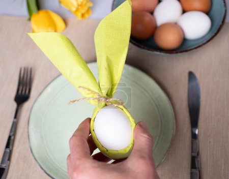 Photo for Egg wrapped in bunny shaped napkin - Royalty Free Image