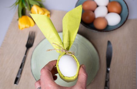 Photo for Egg wrapped in bunny shaped napkin - Royalty Free Image