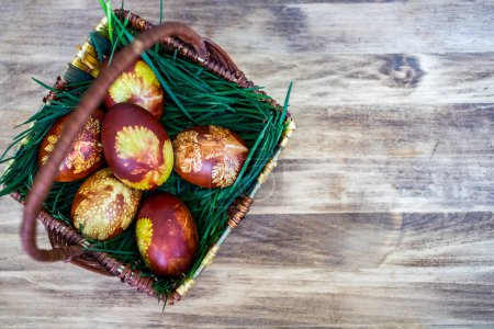 Foto de Huevos de Pascua tradicionales en cesta pintados por ebullición en hojas de cebolla roja y el uso de hojas - comida orgánica - Imagen libre de derechos