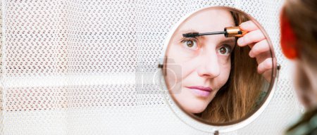 Téléchargez les photos : Femme en miroir appliquant le maquillage - en image libre de droit