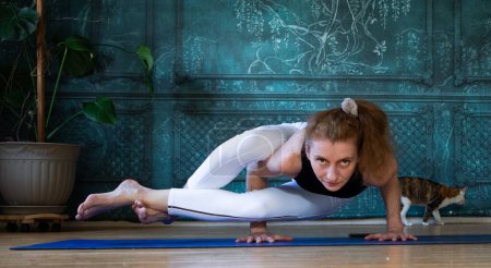 Téléchargez les photos : Femme faisant du yoga contre un mur vert - en image libre de droit