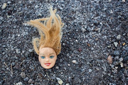 Téléchargez les photos : Tête de poupée dans la boue - en image libre de droit