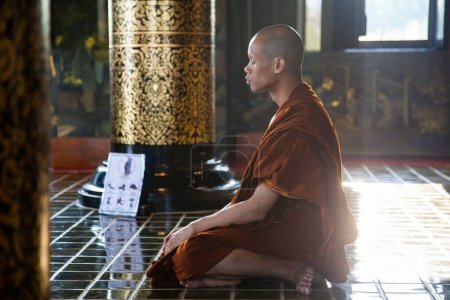 Photo for Buddhist monk meditating in a temple - Royalty Free Image