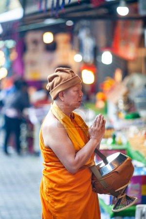 Photo for CHIANG MAI THAILAND- FEBRUARY 19, 2019 :Buddhist monk collecting alms on streets of Chiang Mai - Royalty Free Image