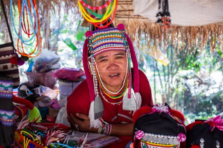 Foto de CHIANG MAI TAILANDIA - FEBRERO, 2019: Mujer de la tribu Hill vendiendo sus bienes en la aldea ecológica Baan Tong Luang cerca de Chiangmai, Tailandia - Imagen libre de derechos
