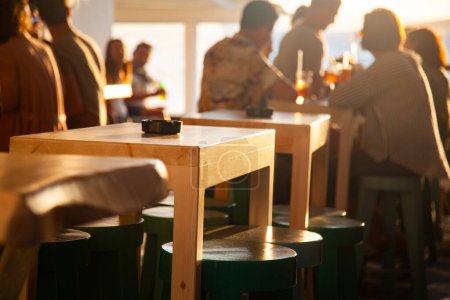 Téléchargez les photos : Personnes dans un bar sur un coucher de soleil d'été - en image libre de droit