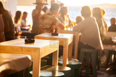 Téléchargez les photos : Personnes dans un bar sur un coucher de soleil d'été - en image libre de droit
