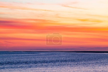 Téléchargez les photos : Coucher de soleil rouge sur la mer bleue - en image libre de droit