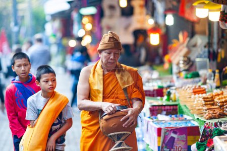 Téléchargez les photos : CHIANG MAI THAILAND- 19 FÉVRIER 2019 : Un moine bouddhiste collecte l'aumône dans les rues de Chiang Mai - en image libre de droit