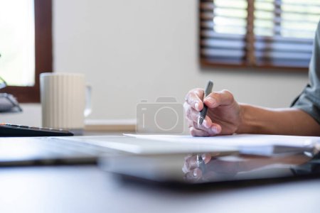 Photo for Beautiful asian businesswoman, entrepreneur, or freelance in casual clothes sitting at desk with paperworks and laptop casually working online in living room at home. At home, business concept. - Royalty Free Image