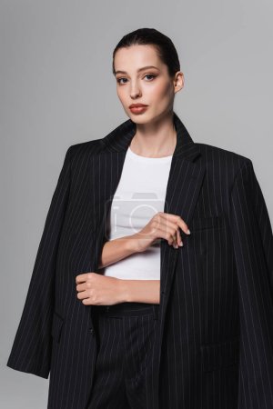 Téléchargez les photos : Portrait de modèle brune élégant veste isolée sur gris - en image libre de droit