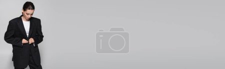 Téléchargez les photos : Veste rayée boutonnée modèle tendance isolée sur gris, bannière - en image libre de droit